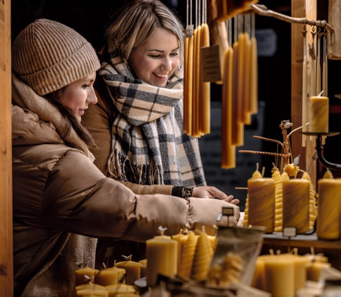 Foto von zwei Frau bei einem Stand mit Kerzen auf dem Oldenburger Weihnachtsmarkt