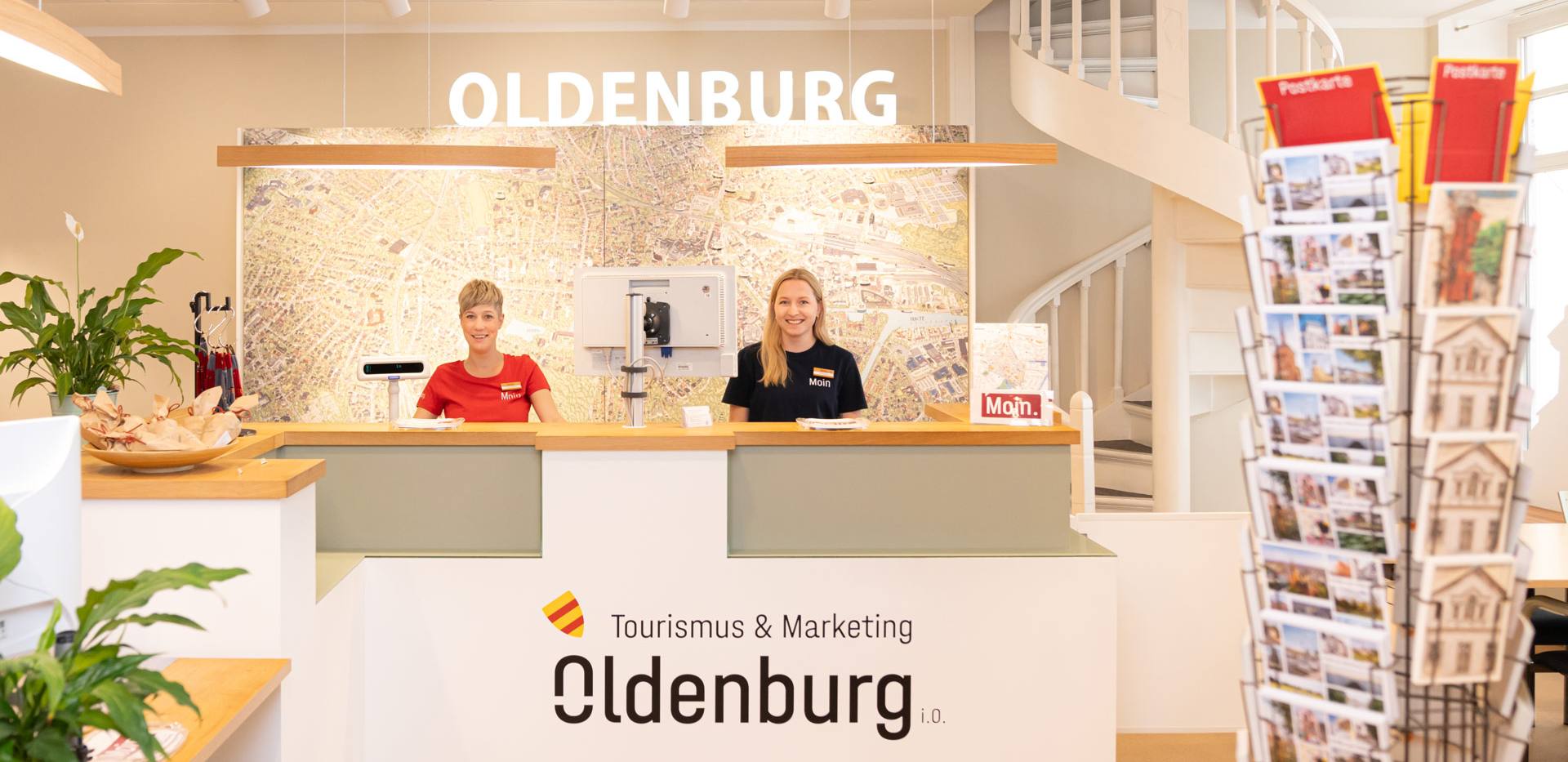 Zwei Mitarbeiterinnen stehen hinter dem Tresen in der Oldenburger Touristinfo