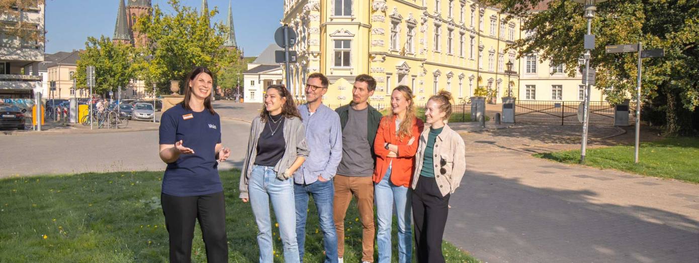 Gruppe bei einer Stadtführung vor dem Oldenburger Schloss