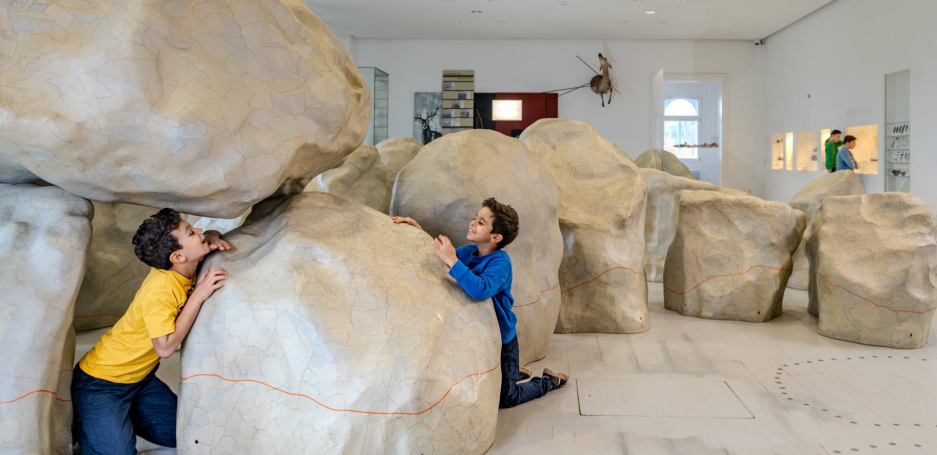 Zwei Kinder spielen im Landesmuseum Natur und Mensch Oldenburg im Modell eines Großsteingrabs. 