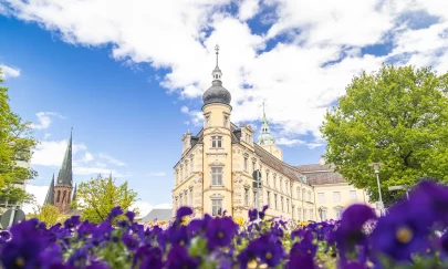 Sehenswürdigkeit Oldenburger Schloss mit Blumen im Vordergrund