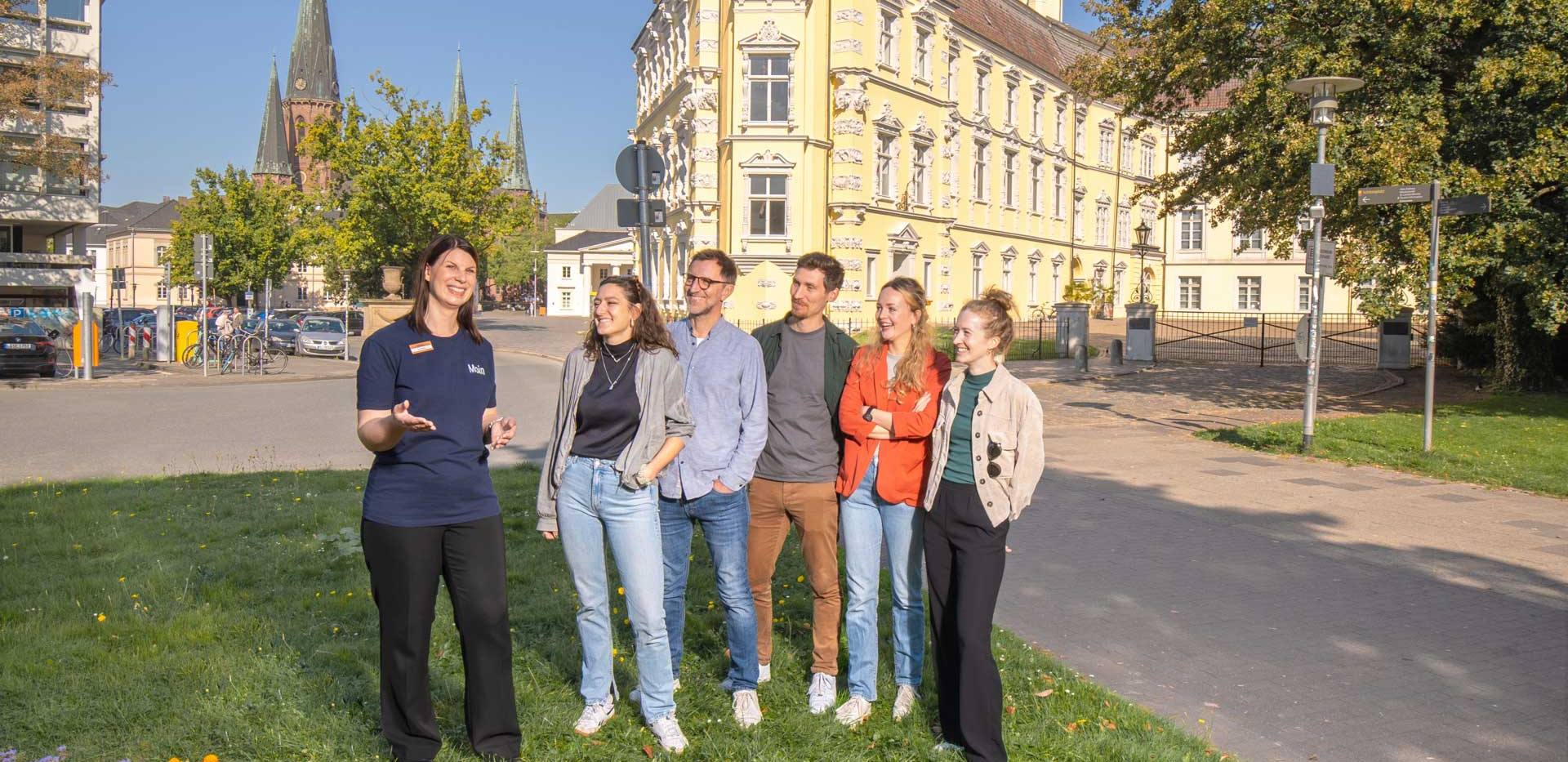 Gruppe bei einer Stadtführung vor dem Oldenburger Schloss