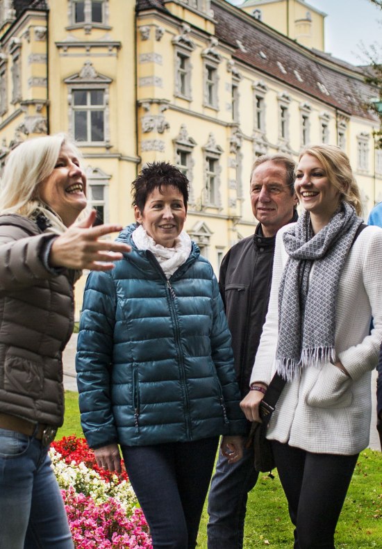 Eine Gruppe mit Gästeführerin vor dem Oldenburger Schloss.